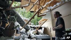Chester Vickers surveys the bedroom of his girlfriend's daughter, which was heavily damaged by a tree that fell in high winds caused by Hurricane Irene, in Port Deposit, Maryland, August 29, 2011