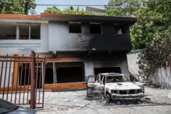 A charred car and building are pictured near the Petionville police station, where suspects in the assassination of President Jovenel Moise are being held, in Petionville, Haiti, July 9, 2021.