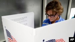 FILE - Ellen Sathe votes at Santa Clara County Registrar of Voters, Oct. 24, 2016, in San Jose, California, where voting rights advocates say they will monitor more polling places than usual on Election Day amid concerns about possible voter intimidation stemming from GOP presidential nominee Donald Trump's repeated assertions that the election is rigged against him.