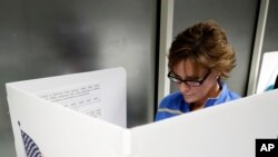  FILE - Ellen Sathe votes at Santa Clara County Registrar of Voters, Oct. 24, 2016, in San Jose, California, where voting rights advocates say they will monitor more polling places than usual on Election Day amid concerns about possible voter intimidatio