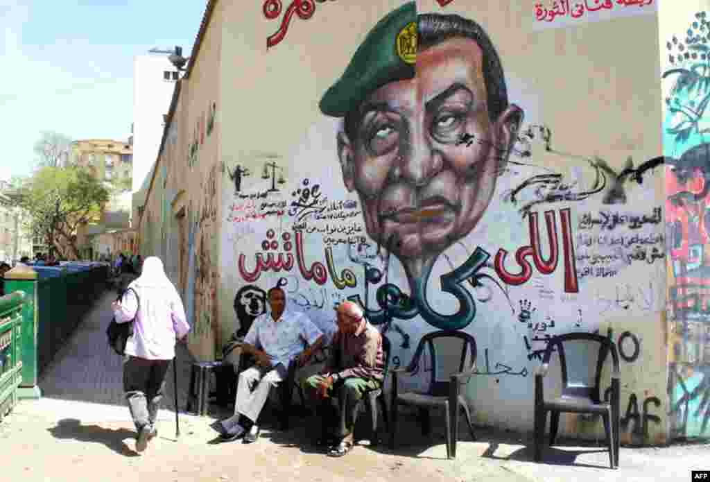 The street art continues nearby with a cartoon merging the faces of the current military ruler Hussein Tantawi with ousted president Hosni Mubarak. (VOA Photo - E. Arrott)