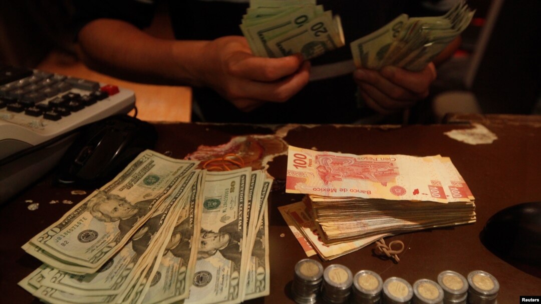 An employee counts U.S. dollar banknotes at a foreign exchange house in Ciudad Juarez, Mexico, Nov. 8, 2016. Mexico will likely raise interest rates to support its currency in the wake of the U.S. election.