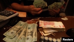 An employee counts U.S. dollar banknotes at a foreign exchange house in Ciudad Juarez, Mexico, Nov. 8, 2016. Mexico will likely raise interest rates to support its currency in the wake of the U.S. election.