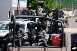 FILE - National Guard and army forces patrol the streets during an operation in a neighborhood of Culiacan, Sinaloa state, Mexico, Sept. 19, 2024.