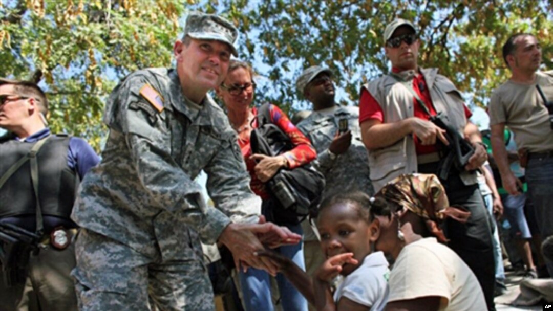US Army special forces Lt. General Kenneth Keen (L) chats with a refugee family in a makeshift shelter camp near the Presidential palace in Port-au-Prince (File)