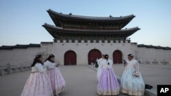 Jessica Hernández, tercera desde la derecha, de Estados Unidos, toma una foto cerca de Gwanghwamun, la puerta principal del Palacio Gyeongbok del siglo XIV, uno de los monumentos más conocidos de Corea del Sur, en Seúl, Corea del Sur, el 4 de diciembre de 2024.