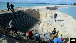 FILE - Workers build a landfill on Tarawa atoll, Kiribati, on March 30, 2004. New Zealand officials said on Jan. 27, 2025, that they are reconsidering all development funding to Kiribati.