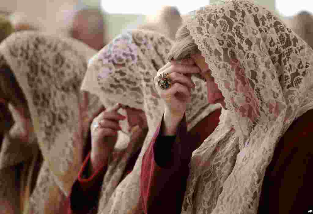 The women of Saint Afram Syrian Orthodox church&#39;s choir pray during morning Christmas mass in Amman, Jordan. Syrian and Iraqi Orthodox Christian families attended morning mass of Christmas and pray for peace in their countries.