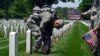 Members of the Old Guard Pvt. Brandon Hyer, left, from Kansas City, Kan., and Pvt. Brad Dixon of Baltimore, Md., place flags in front of headstones at Arlington National Cemetery in Arlington, Va., May 26, 2016. 