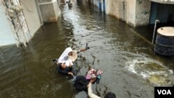 Seorang pria Pakistan melewati genangan air akibat banjir yang sudah mulai menyusut.