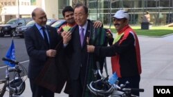 Afghan Ambassador to the UN Mahmoud Saikal, left, watches as Firoz Khan, second from left, and Nader Shah Nangarhari, right, give U.N. Secretary-General Ban Ki-moon a traditional Afghan chapan. (M. Besheer/VOA)