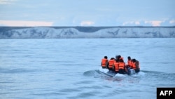 FILE - Migrants travel in a dinghy on the waters of the English Channel toward the south coast of England on Sept. 1, 2020, after crossing from France.