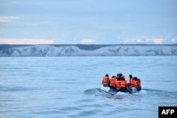 FILE - Migrants travel in a dinghy on the waters of The English Channel toward the south coast of England on Sept. 1, 2020, after crossing from France.