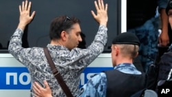 Police officer detains a supporter of Russian investigative journalist Ivan Golunov during a march in Moscow, Russia, Wednesday, June 12, 2019.