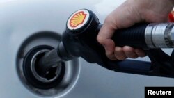 A driver fills up with fuel at a Shell petrol station in London, Britain, May 15, 2013. 