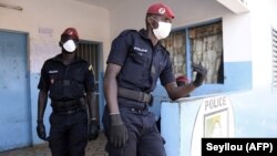 Des policiers portent des masques au marché aux poissons de Pikine à Dakar, au Sénégal, le 24 mars 2020. (Photo by Seyllou / AFP)