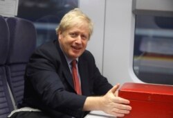 FILE - Britain's Prime Minister Boris Johnson sits on a train in London, Dec. 6, 2019, on the campaign trail ahead of the general election on Dec. 12.