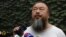 Chinese dissident artist Ai Weiwei listens as his lawyer announces over speakerphone the verdict of Ai's lawsuit against the tax authorities in Beijing, July 20, 2012.
