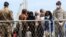 FILE - Migrants wait to disembark an Italian Navy ship in the port of Palermo, Sicily, southern Italy, May 2, 2014.