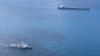 In this undated photo released by Indonesian Maritime Security Agency (BAKAMLA), a BAKAMLA ship escorts Iranian-flagged tanker MT Horse, top right, as they sail towards Batam Island, Indonesia. 