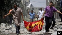 Palestinians, one holding a white flag, flee Gaza City's Shijaiyah neighborhood, northern Gaza Strip, July 20, 2014. 