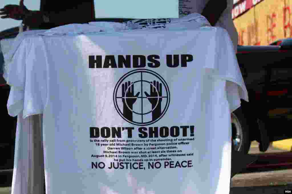 Camisas con la frase "manos arriba, no dispare" se venden en varias esquinas de la ciudad de Ferguson, cerca de donde un policía mató al joven afroestadounidense Michael Brown. [Foto: Gesell Tobias, VOA]