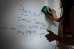 A volunteer teacher erases the board after teaching her Christian Burmese refugees English in Kuala Lumpur, Malaysia, March 11, 2017.