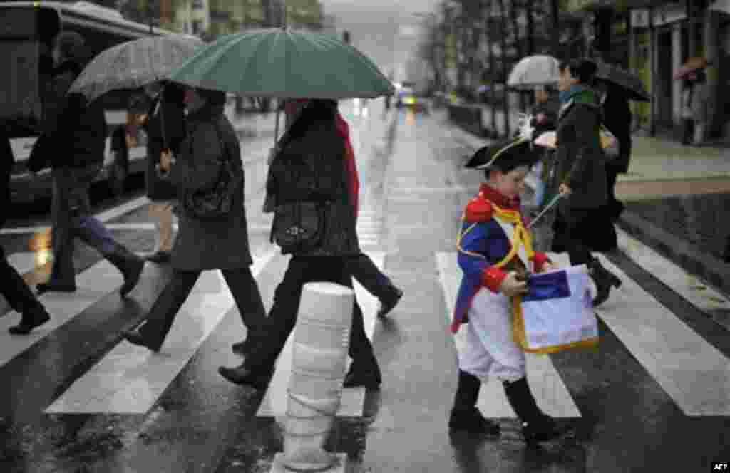 A ''Tamborillero'' wearing their uniform crosses a pedestrian crossing during the 'El Dia Grande', the main day of the San Sebastian feasts, in the Basque city of San Sebastian, northern Spain, Friday, Jan. 20, 2012. From midnight to midnight companies of