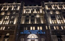 Activists from the Population Connection Action Fund project a message onto the Trump International Hotel, to protest the global gag rule, Washington, Jan. 23, 2019.