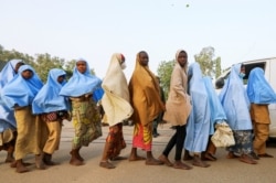 FILE - Girls who were kidnapped from a boarding school in the northwest Nigerian state of Zamfara walk in line after their release, in Zamfara, Nigeria, March 2, 2021.