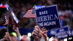 Delegates wave signs and flags during the final day of the Republican National Convention in Cleveland, July 21, 2016. 