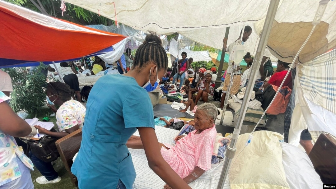 Umukenyezi yakomeretse ariko aritabwaho n'umuforoma hanze y'ibitaro, inyuma ya nyamugigima yo kuwa gatandatu i Les Cayes, Haiti, Kw'itariki ya 16/08/2021.
