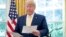 Archivo - El presidente Donald Trump revisa documentos en la Oficina Oval. Oct. 11, 2019. 