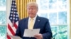 FILE - President Donald Trump is seen holding documents in the Oval Office of the White House, in Washington, Oct. 11, 2019. 