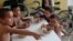 FILE - Honduran children have meals at the Todo por ellos (All for Them) immigrant shelter in Tapachula, Chiapas, in southern Mexico, June 26, 2014.