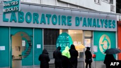 22일 프랑스 파리의 한 진료소 입구 앞에 신종 코로나바이러스 검사를 받기 위한 사람들이 줄 서 있다.