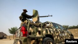 FILE - Nigerian military prepare to cordon an area around Maiduguri, Nigeria, Feb. 16, 2019. Amnesty International said the military burned villages and displaced hundreds in its hunt for extremists.