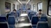 People wearing masks as a precaution against the spread of the new coronavirus ride an empty train in Buenos Aires, Argentina. 