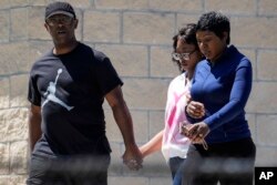 Parents walk their child out of Apalachee High School after a shooting at the school in Winder, Georgia, Sept. 4, 2024.