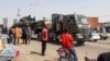 Les passants regardent un char transporté par camion dans les rues de N'Djamena au Tchad, le 3 janvier 2020, alors que les troupes tchadiennes reviennent d'une mission de combat contre Boko Haram au Nigeria voisin.