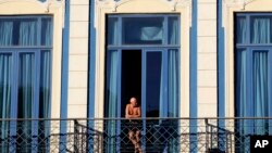 Un turista observa la ciudad desde el balcón de su hotel en La Habana.