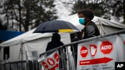 Para pasien sambil mengenakan masker dan sarung tangan antre untuk mendapatkan tes COVID-19 di Rumah Sakit Pusat Brooklyn, New York, 29 Maret 2020. (Foto: AP)