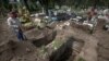 A worker digs graves in the COVID-19 section of a cemetery on the outskirts of Mexico City, Sept. 1, 2020.