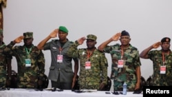 Military personnel gesture as the ECOWAS anthem is played during a meeting of the Committee of Chiefs of Defense staff on the deployment of the ECOWAS standby force in the Republic of Niger, in Accra, Ghana. August 17, 2023. (REUTERS/Francis Kokoroko)