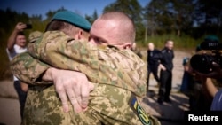 Ukrainian prisoners of war are seen after a swap with Russian POWs, at an unknown location in Ukraine, Sept. 14, 2024. (Ukrainian President Volodymyr Zelenskyy on Telegram via Reuters)