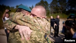 Ukrainian POWs are seen after a swap at an unknown location in Ukraine