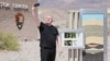 Scott Hughes, turis dari Swansea, Wales, Inggris, berswafoto di samping layar digital yang menunjukkan suhu udara 54 Celsius, selama gelombang panas di Taman Nasional Death Valley di California, 16 Juli 2023.