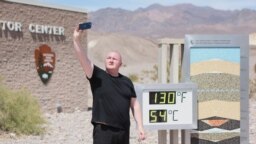Seorang pengunjung mengambil selfie di samping tampilan digital suhu udara di Taman Nasional Death Valley di California yang mencapai lebih dari 54 Celcius, saat gelombang panas pada 16 Juli 2023 lalu (foto: dok).