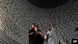 Visitors look at a wall displaying the names of the victims of 2004 Indian Ocean tsunami, at the Tsunami Museum in Banda Aceh, Aceh province, Indonesia, Dec 14, 2024. 