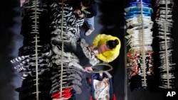 A woman checks on a clothing price tag at a fashion retailer store having promotion sale at a shopping mall in Shenzhen, China's Guangdong province, Nov. 1, 2019. 